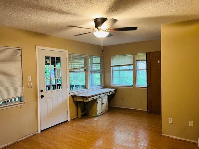 Doorway featuring a ceiling fan, light wood-style floors, a textured ceiling, and baseboards | Image 18