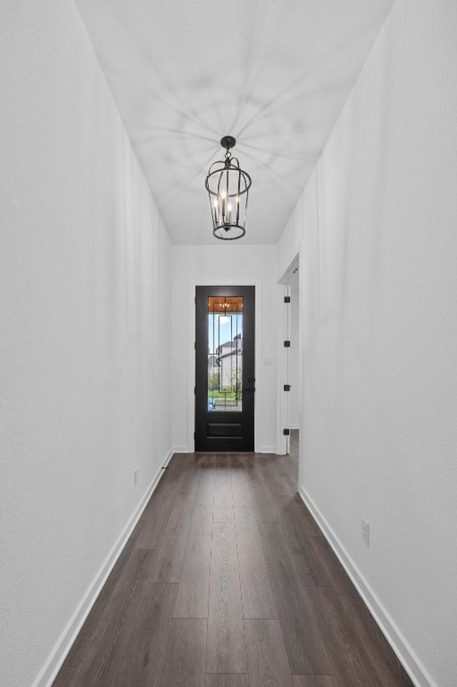 Doorway with a chandelier and dark wood finished floors | Image 17