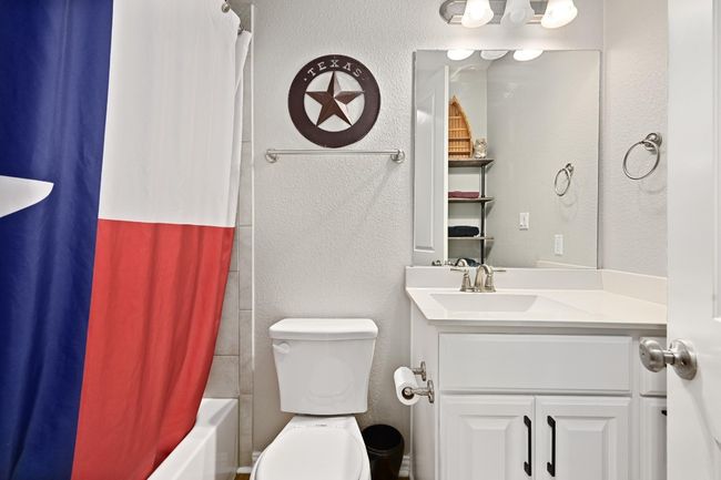 Full bathroom featuring vanity, a textured wall, and shower / bath combo | Image 20