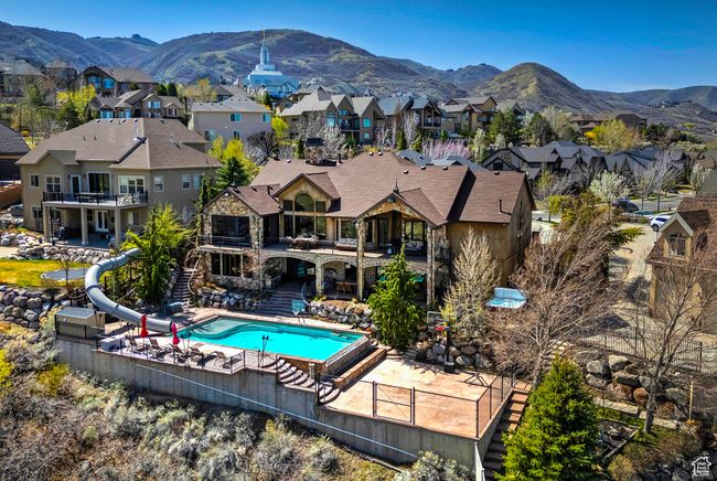 View of swimming pool featuring a patio, a residential view, a water slide, and a mountain view | Image 8