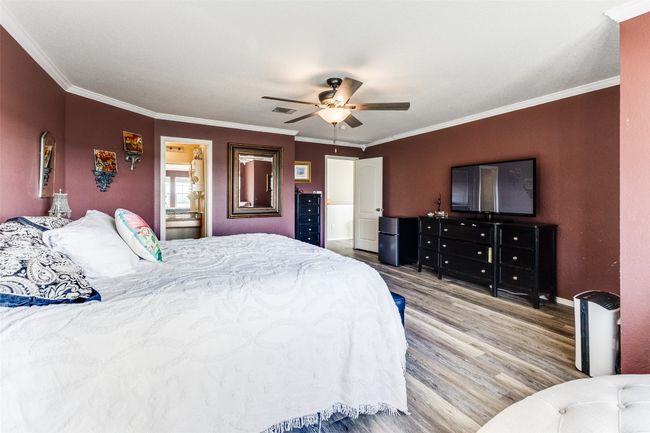 Bedroom with wood finished floors, crown molding, baseboards, and a ceiling fan | Image 31