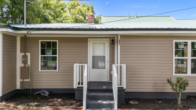 Property entrance featuring a metal roof and a chimney | Image 7