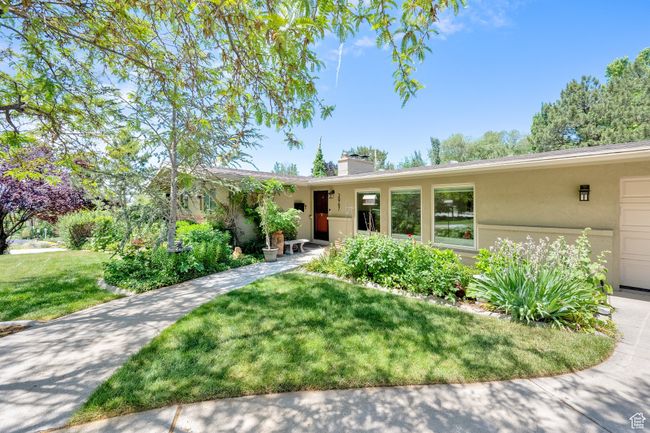 Single story home featuring stucco siding, a front lawn, and a chimney | Image 4