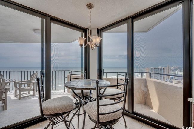 Sunroom / solarium featuring a chandelier and a water view | Image 20