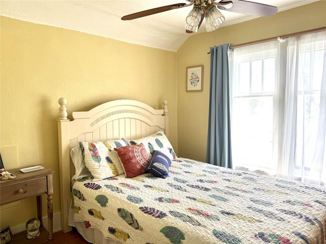 Bedroom featuring vaulted ceiling, wood finished floors, ceiling fan, and a textured wall | Image 25