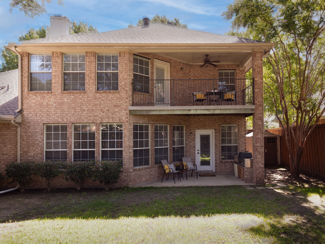 Back of house with a balcony, ceiling fan, brick siding, a patio, and a chimney | Image 31