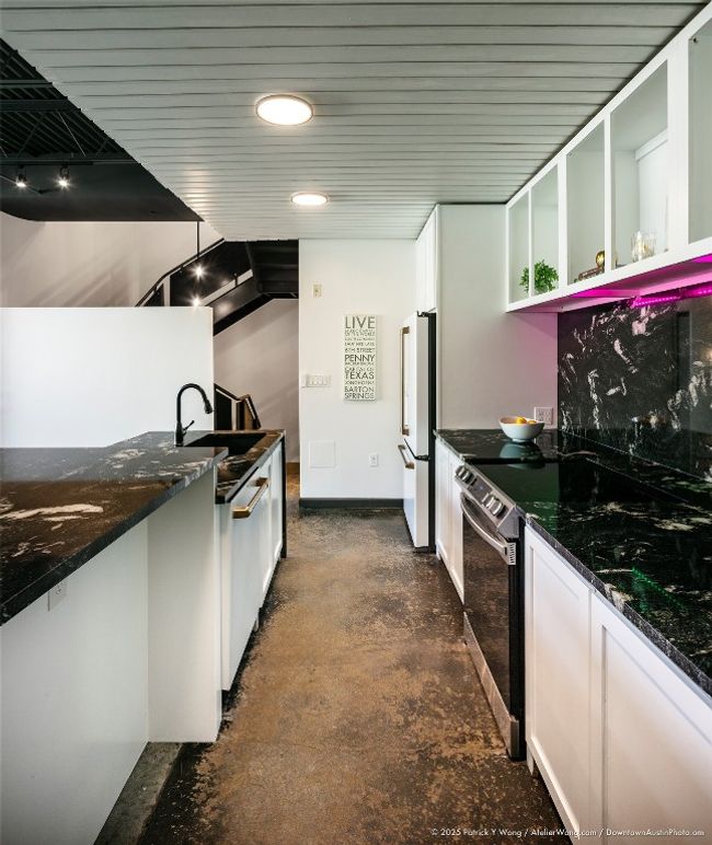 Kitchen featuring stainless steel electric stove, freestanding refrigerator, white cabinets, dark stone countertops, and glass insert cabinets | Image 6