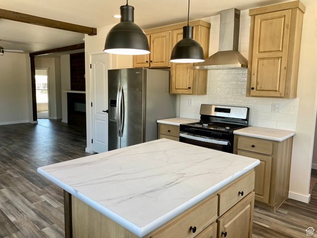Kitchen with wall chimney exhaust hood, stainless steel appliances, tasteful backsplash, dark wood-style flooring, and light brown cabinets | Image 5