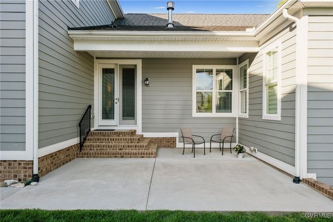 Extra large brushed concrete courtyard patio with paved walkway to front of garage. Perfect spot for outdoor dining. | Image 44
