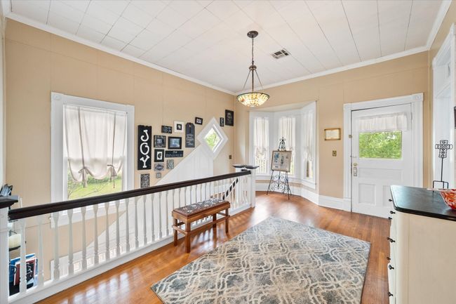 Entrance foyer with ornamental molding, plenty of natural light, and wood finished floors | Image 22