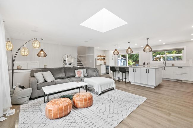 Living area featuring light wood-type flooring, recessed lighting, beverage cooler, and a skylight | Image 18