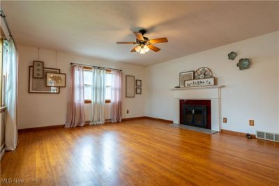 Unfurnished living room with light wood-type flooring and ceiling fan | Image 3