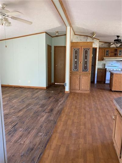 Kitchen with stove, dark hardwood / wood-style floors, ornamental molding, and a textured ceiling | Image 3