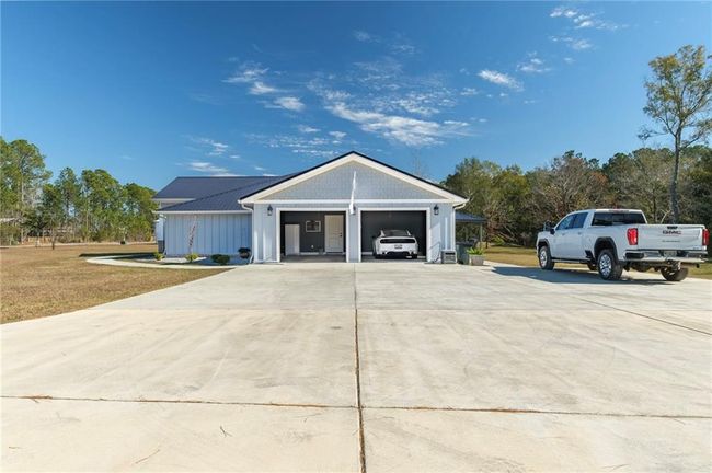 View of front of property featuring a front yard and a garage | Image 4