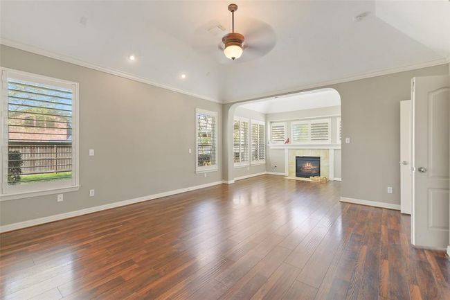 Fantastic Primary bedroom down! Large sitting area with a 2nd fireplace. Plantation shutters, neutral paint, updated flooring, Vanity lights, Crown Molding and has a great view of the pool! | Image 21