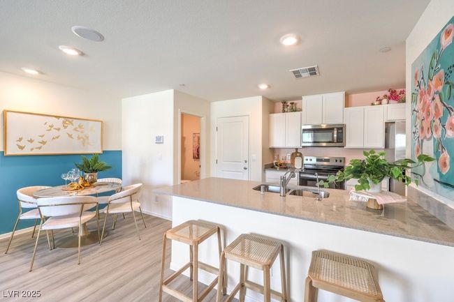 Kitchen featuring a sink, visible vents, white cabinetry, a peninsula, and appliances with stainless steel finishes | Image 13