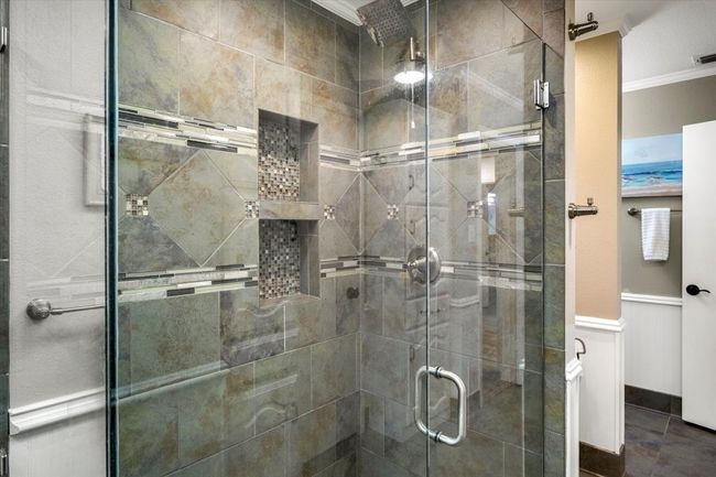 Bathroom with visible vents, crown molding, a wainscoted wall, and a stall shower | Image 19