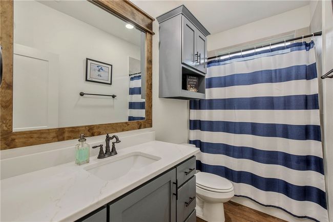 Full bath with toilet, wood finished floors, vanity, and a shower with shower curtain | Image 23