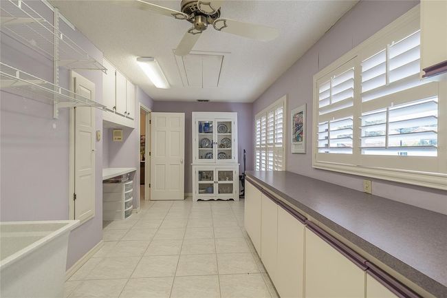 utility room, built in cabinets, ironing board and desk | Image 20