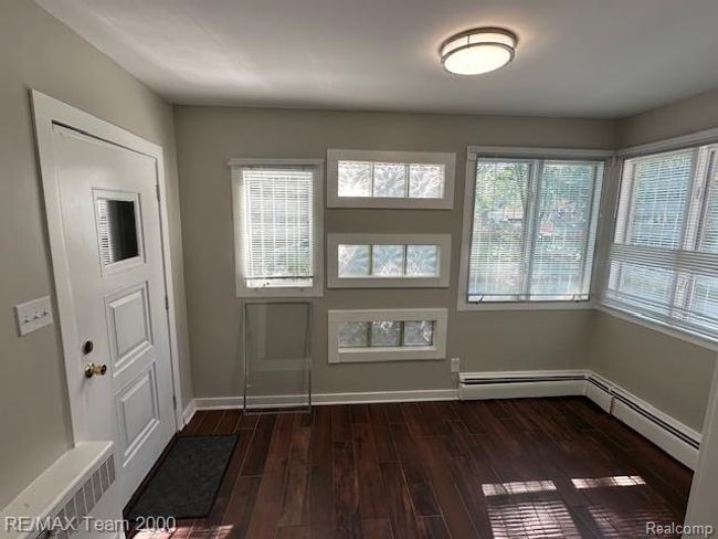 Foyer entrance featuring dark wood-type flooring, radiator heating unit, and baseboard heating | Image 8