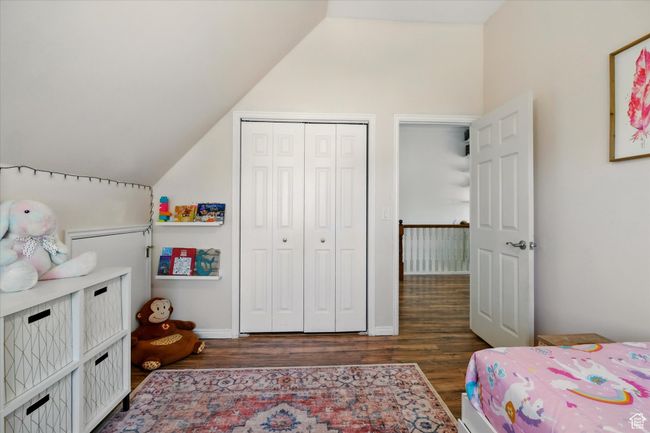 Bedroom with vaulted ceiling, wood finished floors, and a closet | Image 18