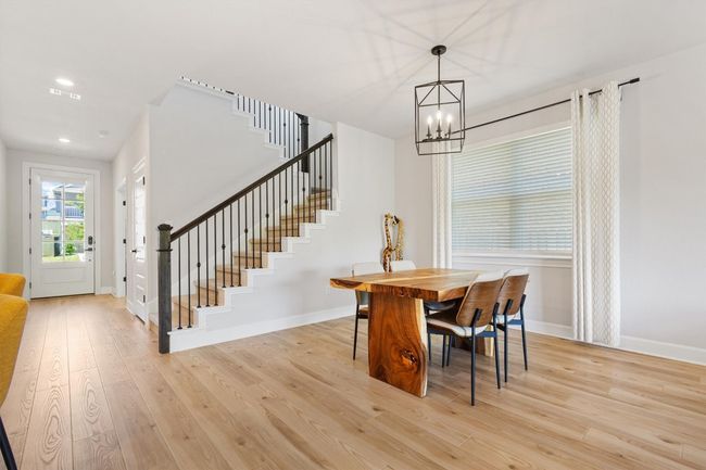 Dining room with stairway, a chandelier, light wood finished floors, baseboards, and recessed lighting | Image 5