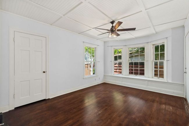 A bay window with built-in seating and storage is the highlight of this bedroom. Check out the beadboard ceilings in both bedrooms! | Image 12
