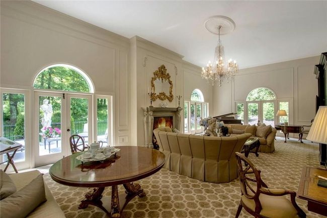 Carpeted living room with an inviting chandelier | Image 6