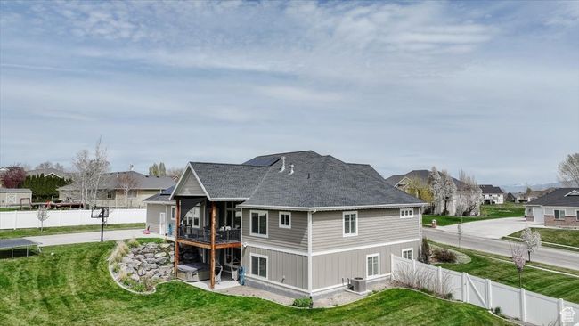 Rear view of property featuring a fenced backyard, a residential view, a yard, and central AC | Image 19