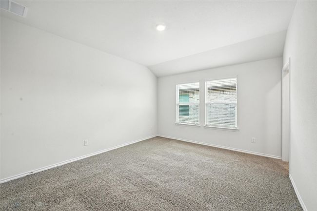 Carpeted empty room featuring vaulted ceiling and baseboards | Image 15