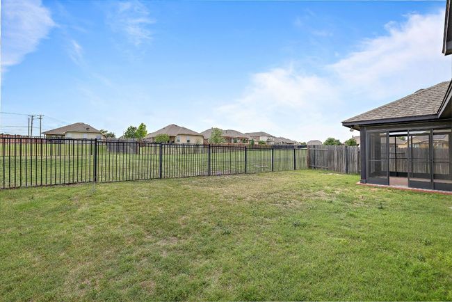View of yard featuring a fenced backyard, a sunroom, and a residential view | Image 30