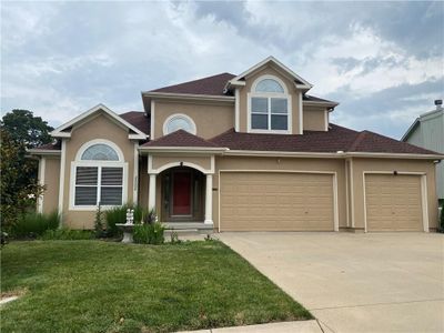 View of front of home featuring a front yard and a garage | Image 1