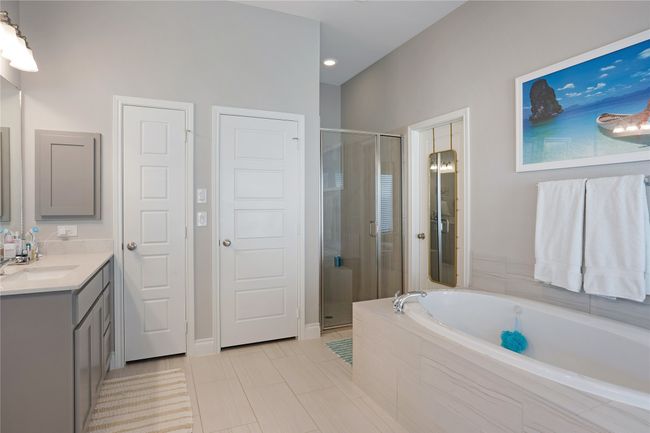 Bathroom with vanity, a garden tub, a shower stall, and tile patterned flooring | Image 17