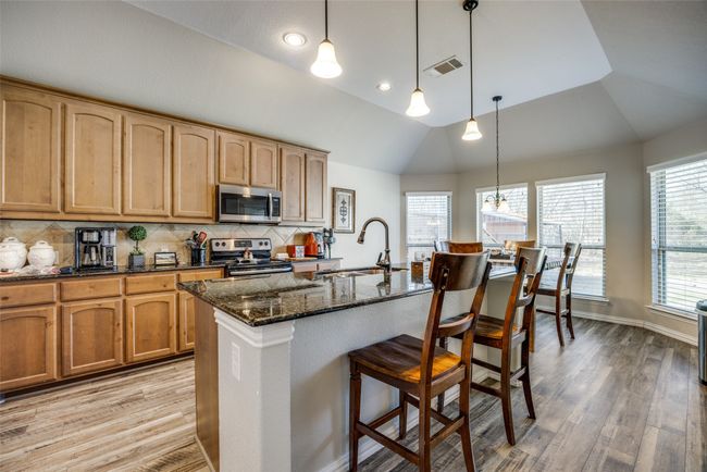 Kitchen featuring lofted ceiling, appliances with stainless steel finishes, sink, and a center island with sink | Image 6