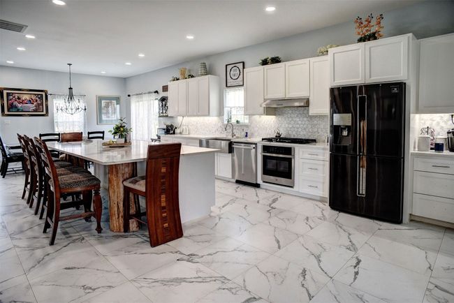 Shown: kitchen with center island/table and good size counter shown in background | Image 15