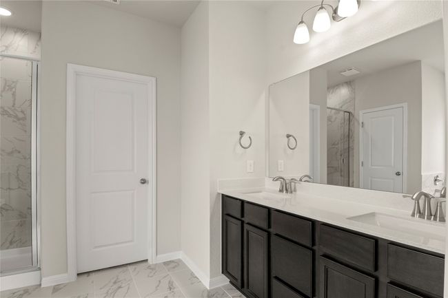 Bathroom featuring marble finish floors, a marble finish shower, double vanity, and recessed lighting | Image 22