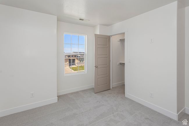 Unfurnished bedroom featuring baseboards, visible vents, carpet floors, and a walk in closet | Image 22