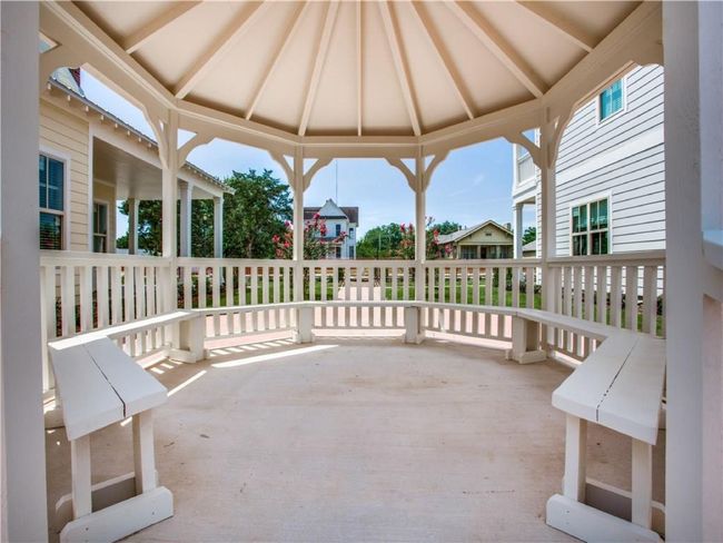 View through the gazebo shows the beautifully renovated two-story home at the southwest corner of Cedar St and Church St. | Image 15