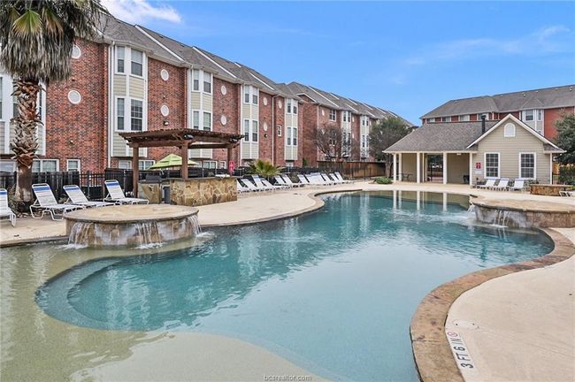 Community pool featuring a residential view, a pergola, an outdoor bar, fence, and a patio area | Image 28