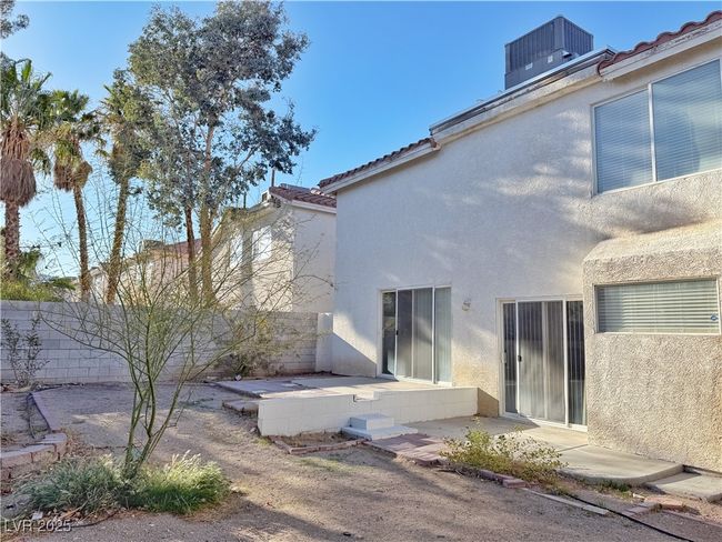 Rear view of house featuring stucco siding, a patio, and central AC | Image 48