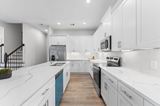 Stunning kitchen with quartz countertops, ample cabinetry, and stainless steel appliances included. | Image 13