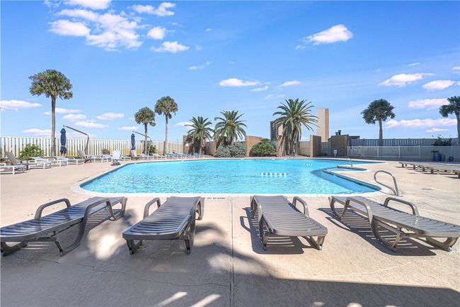 Nice pool area with lounge chairs and hot tub. | Image 31