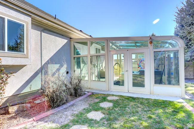 View of side of property featuring stucco siding and a sunroom | Image 49