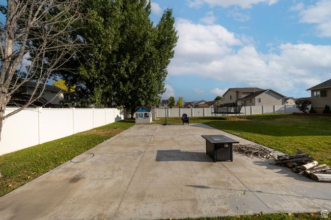 Fenced backyard with a trampoline, a patio area, a residential view, and a shed | Image 27
