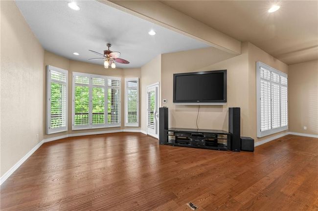 Unfurnished living room with wood finished floors, a ceiling fan, recessed lighting, and baseboards | Image 37