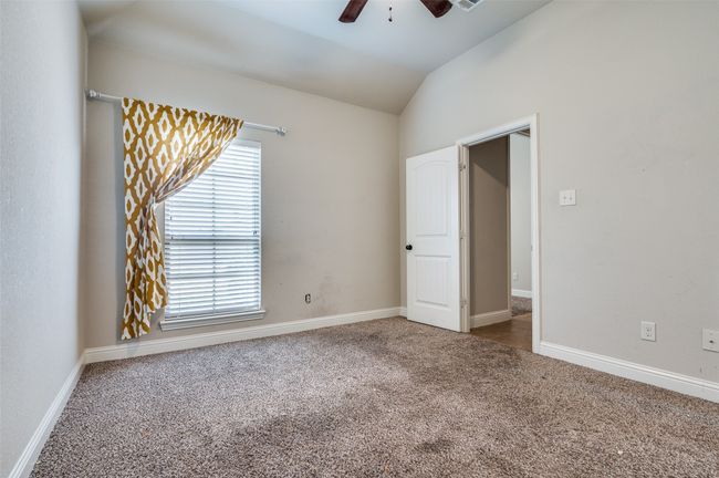 Unfurnished bedroom with carpet flooring, lofted ceiling, and ceiling fan | Image 15