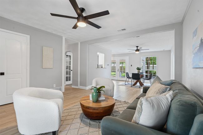 Living room featuring a ceiling fan, light wood-style flooring, french doors, and arched walkways | Image 7
