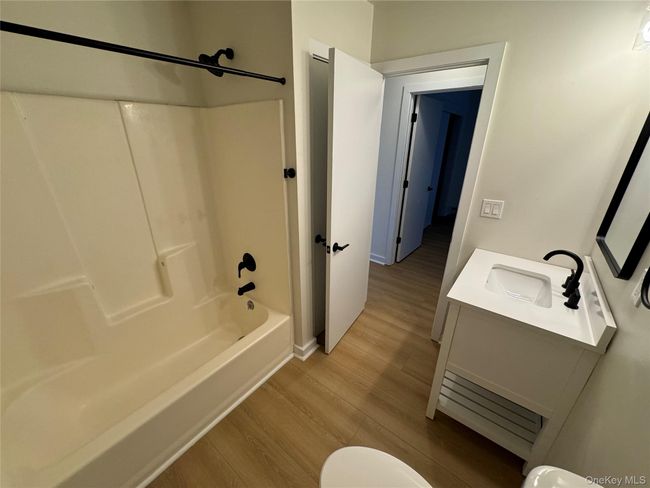 Bathroom featuring vanity, wood finished floors, and shower / bathtub combination | Image 13