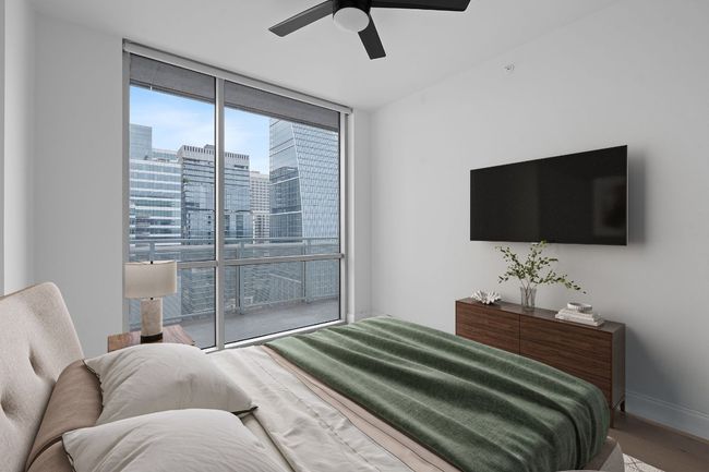 Bedroom with a wall of windows, wood finished floors, and a ceiling fan | Image 8