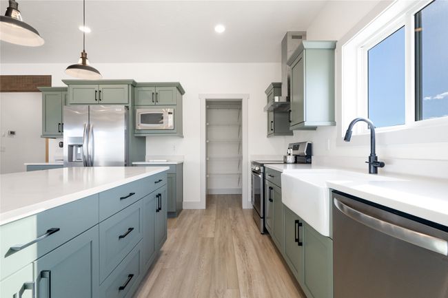 Kitchen featuring stainless steel appliances, light countertops, light wood-style floors, recessed lighting, and pendant lighting | Image 16